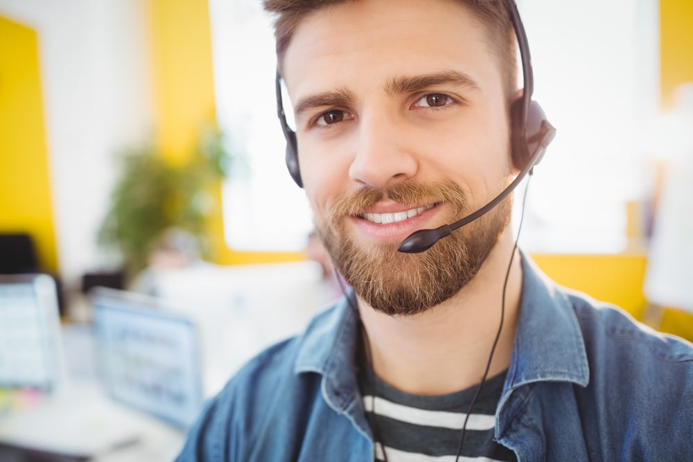 Portrait of confident young male executive wearing headphones at creative office